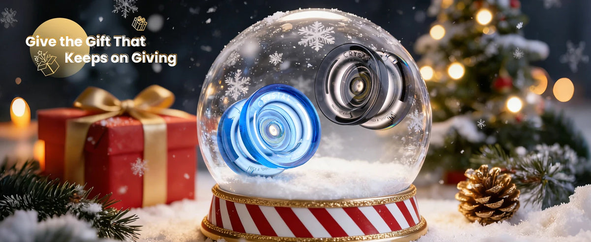 A clear glass sphere containing a blue crystal plastic yo-yo is displayed on a striped base with festive holiday decorations.