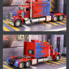 A red and blue Peterbilt 389 scale diecast truck model with chrome accents displayed on a studio background.