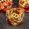 A clear resin die shaped like a pyramid with golden elven numbers on a dark surface.