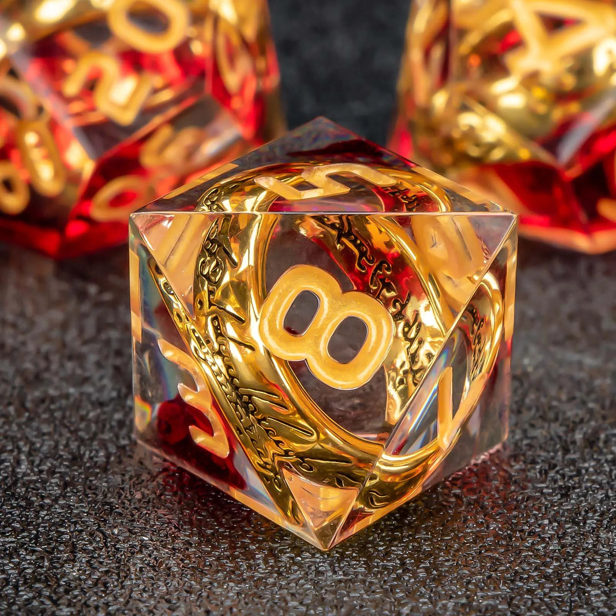 A clear resin die shaped like a pyramid with golden elven numbers on a dark surface.