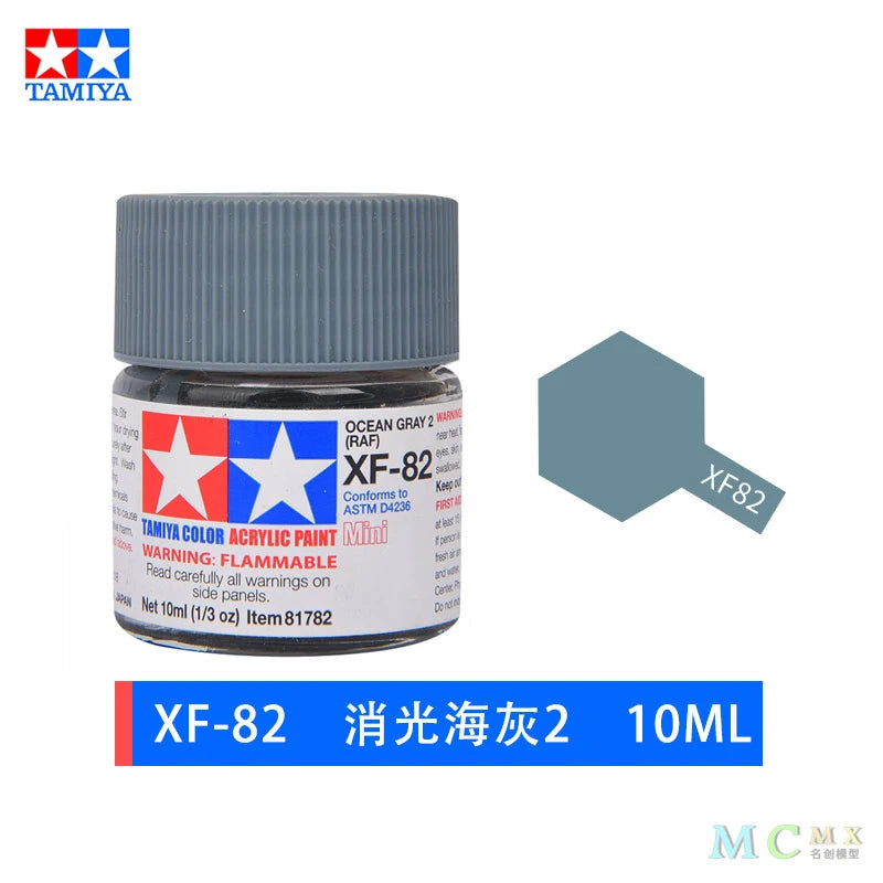 A glass jar of XF-82 model paint, labeled as Ocean Gray 2, with a silver cap.