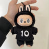 A black plush toy resembling a rabbit with white markings and the number 10 on its chest is held in a hand.
