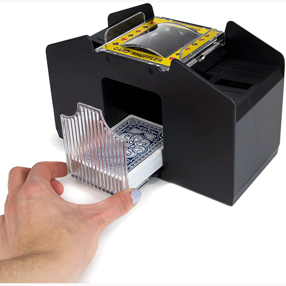 A hand is inserting a deck of cards into a black automatic card shuffler device.