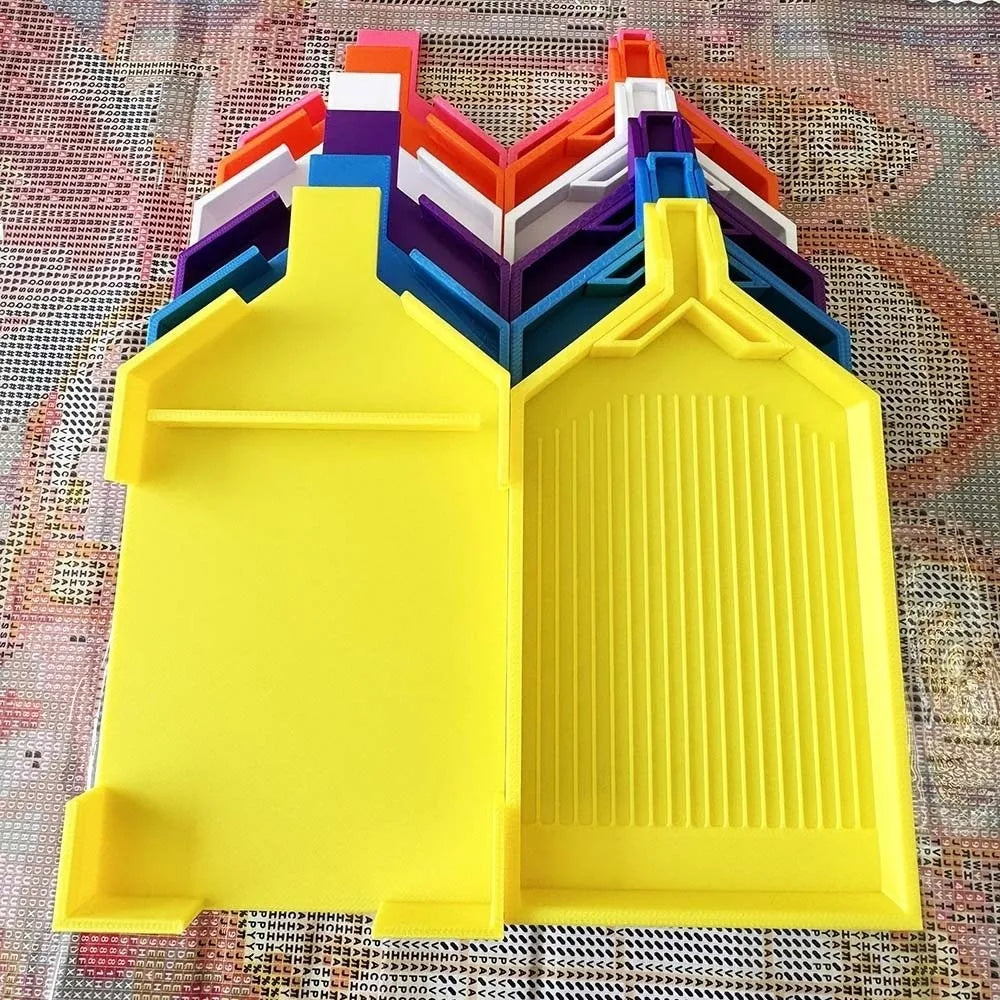 A set of colorful, pop-up trays for diamond painting beads, featuring a large yellow tray and multiple colored plugs.