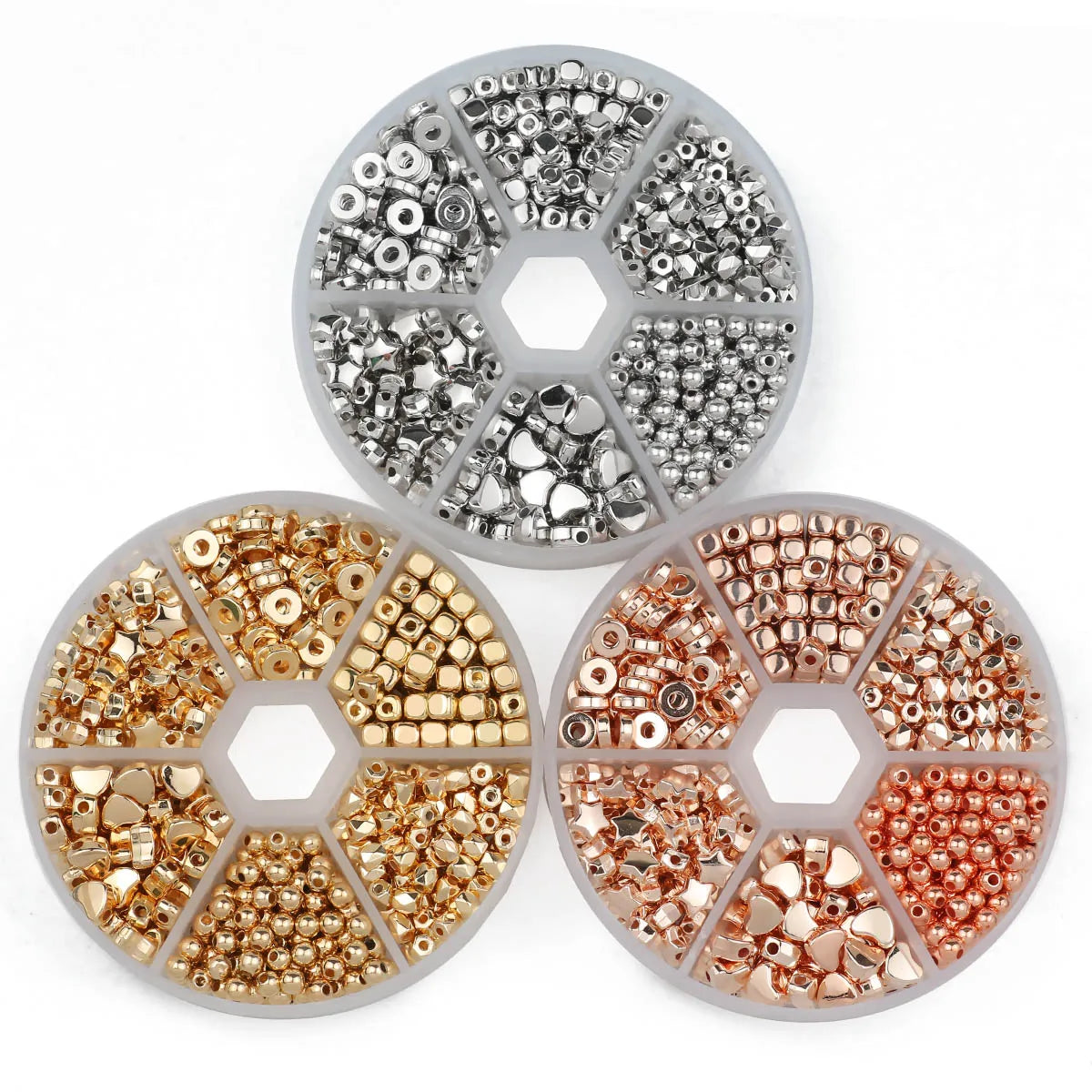 A collection of gold and silver plated beads for jewelry making, displayed in circular trays.