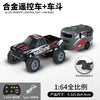 A black and red 1:64 scale remote control monster truck with a gray body, shown next to an accessory.