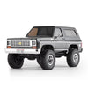 A black 1:24 scale Chevrolet K5 Blazer RC crawler with large off-road tires and a chrome bumper.