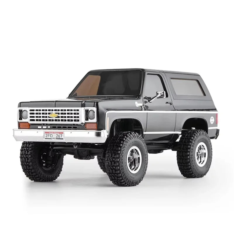 A black 1:24 scale Chevrolet K5 Blazer RC crawler with large off-road tires and a chrome bumper.