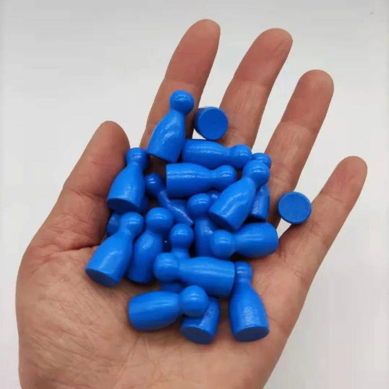 A hand holds a set of ten bright blue wooden chess pawns for board games.