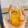 A hand holds a clear bottle filled with yellow liquid labeled Chiboki drink cup toy