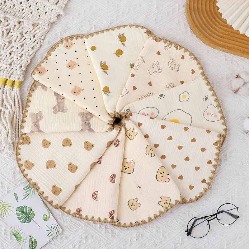 A round, multi-layered flat pillow made of light beige cotton gauze with cute animal embroidery for newborns.