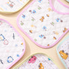 A collection of soft cotton baby bibs in various patterns and colors laid out on a light background.