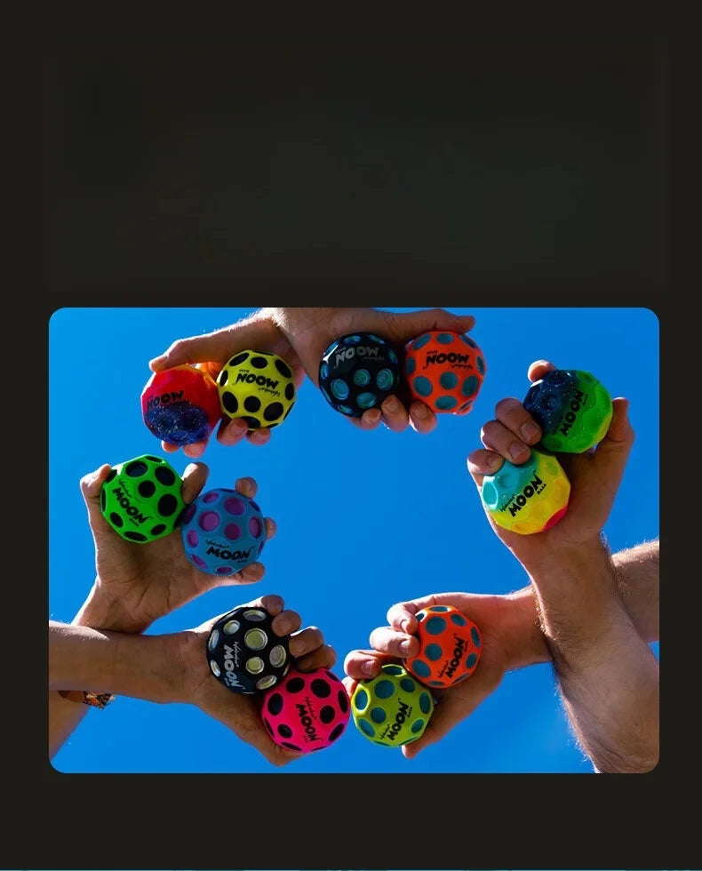 Several hands are holding and playing with colorful moon balls against a bright blue sky.