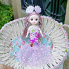 A small mermaid doll with pink hair and a purple sequin dress is displayed in a woven basket.
