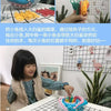 A child plays with a shark bite prank board game featuring colorful plastic pieces on a grid surface.