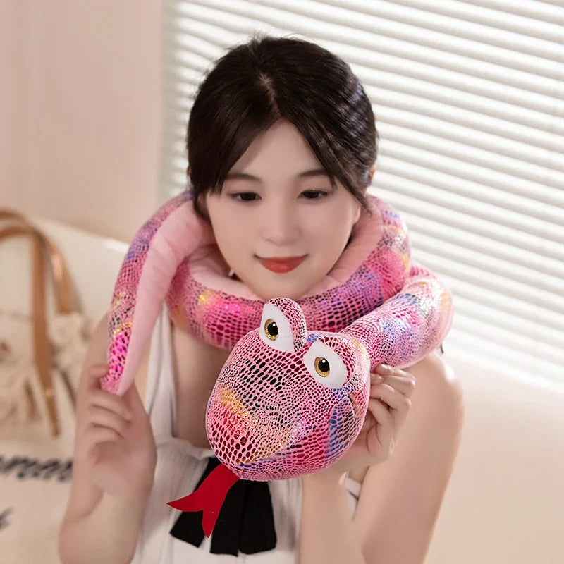A woman is holding a pink and purple cartoon snake plush toy with a textured skin appearance.
