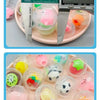 A collection of transparent plastic eggshell party favors in various colors and shapes arranged on a pink tray.