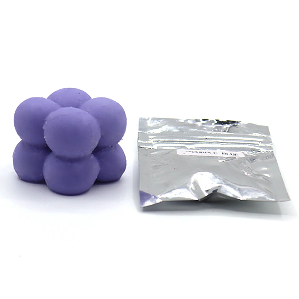 A pile of purple candle dye chips for soy wax, beeswax, and paraffin wax.