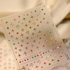 A sheet of sparkling diamond nail art stickers featuring various colored rhinestones and gems.