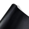 A close-up view of a black PU leather self-adhesive repair patch rolled up.