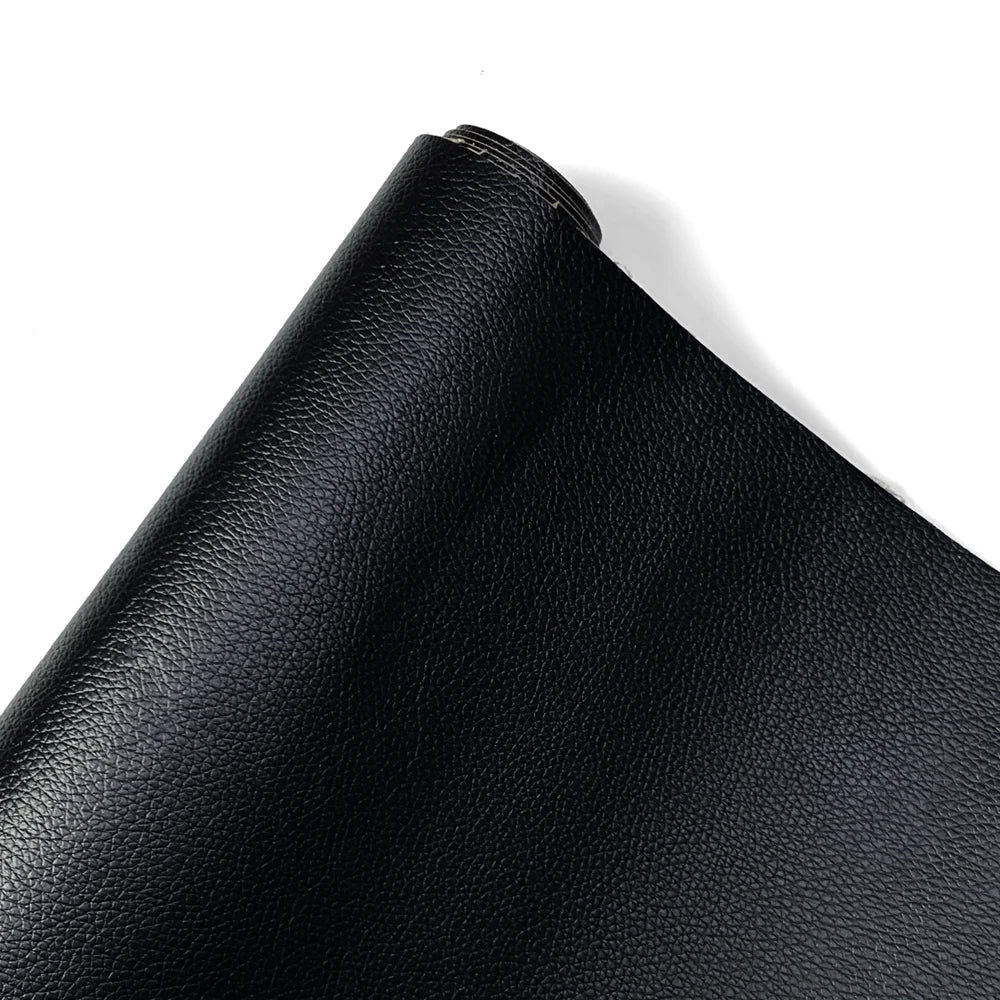 A close-up view of a black PU leather self-adhesive repair patch rolled up.