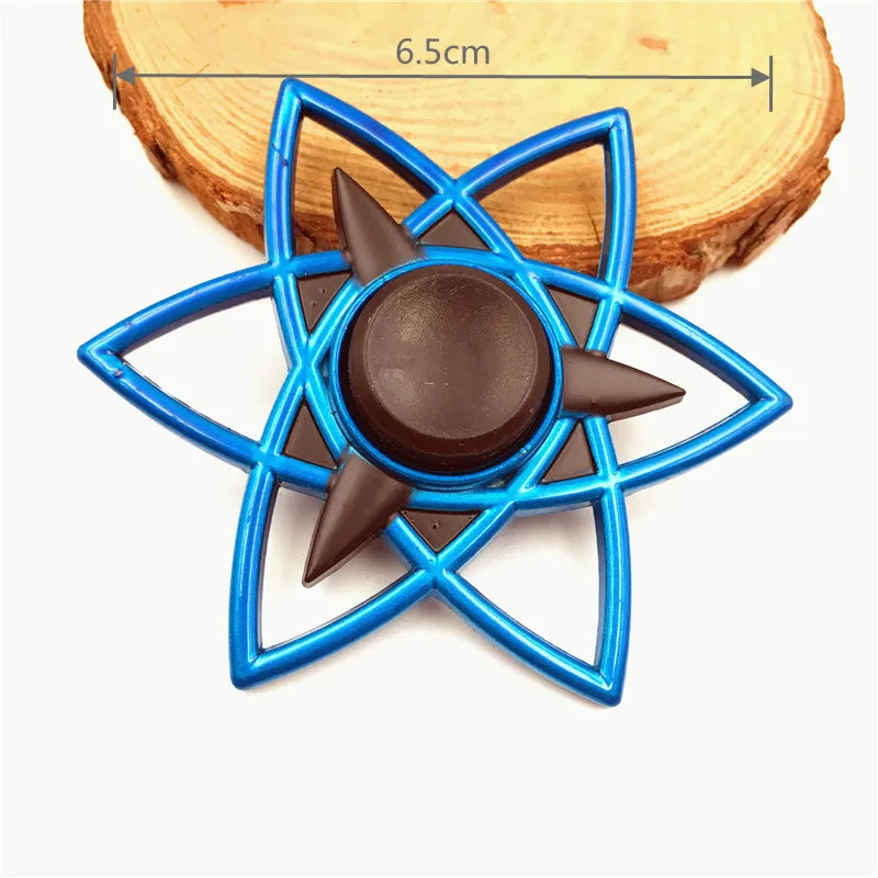 A blue metal fidget spinner with a rainbow finish resting on a wooden surface.