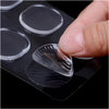 A hand is pressing a clear silicone drum dampening pad onto a black surface for tone control.
