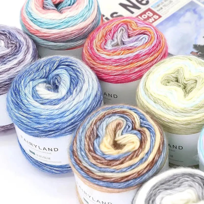 A collection of gradient rainbow yarn spools in various colors and textures for knitting and crochet projects.