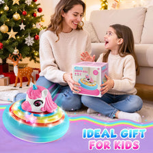 A girl and a woman are holding a unicorn hover soccer ball with LED lights in a living room setting.
