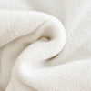 A close-up of a white fleece-lined winter coat folded in a soft, rounded shape.