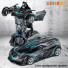 A black and teal transformable robot sports car toy is shown in a dynamic pose against a gray background.