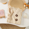 A beige knit sweater vest for girls featuring a flower shape design and ruffled edges, displayed on a white surface.