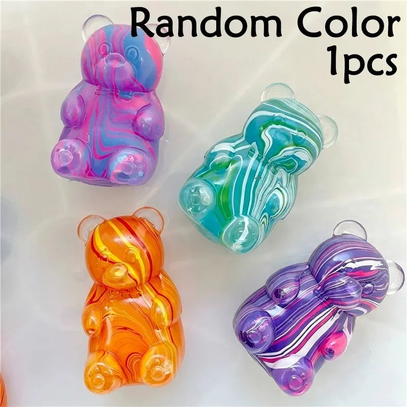 Four colorful gummy bear squeeze toys in various shades of pink, blue, green, and orange.