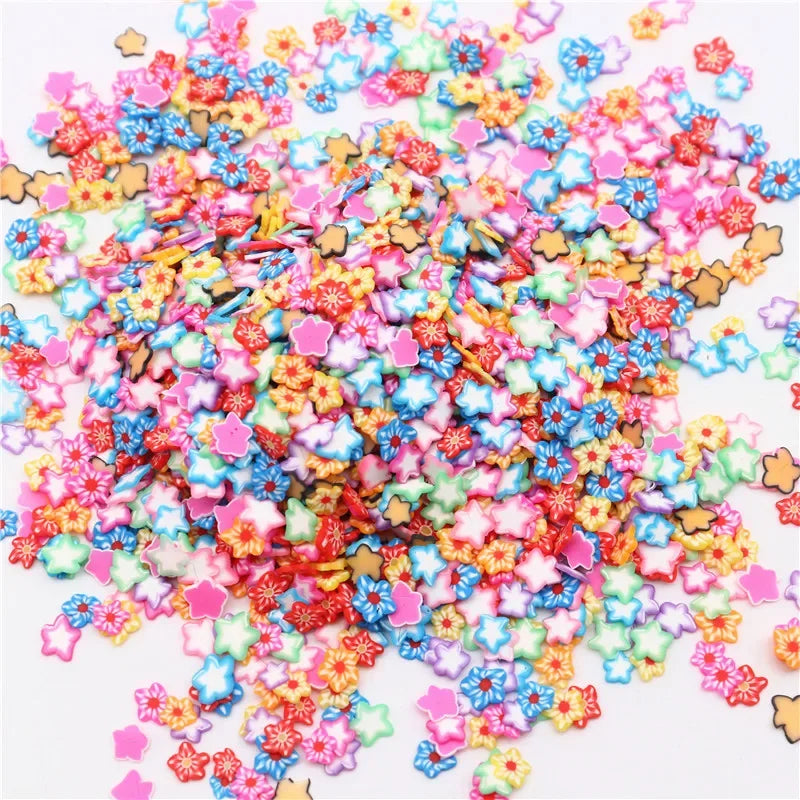 A colorful pile of polymer clay flower charms in various shades of pink, blue, and yellow.