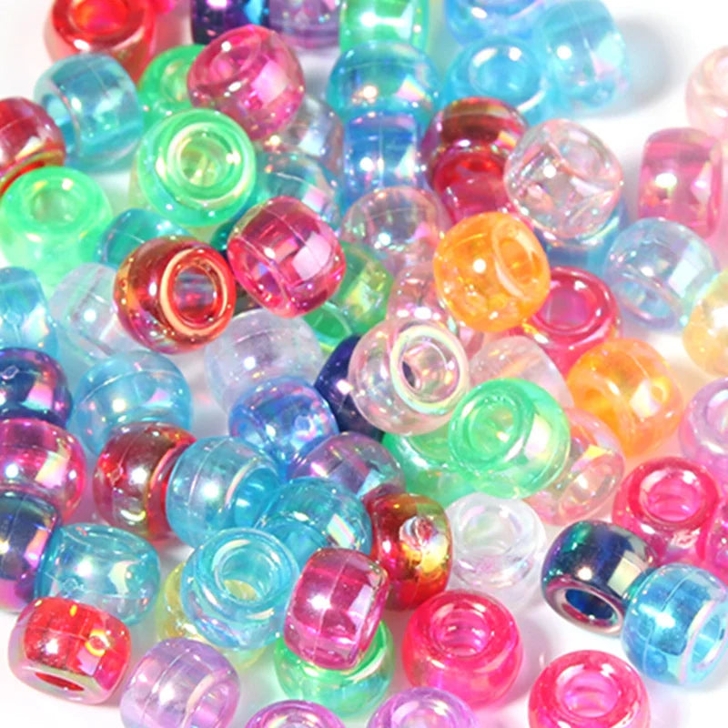 A pile of colorful rainbow pony beads in various shades of pink, blue, green, and orange.