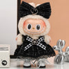 A plush Labubu doll wearing a black and white flannel outfit with a black bow and silver shoes.