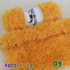 A pile of bright orange fluffy faux fur yarn with a label showing Snow Fox branding.