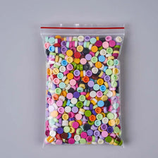 A clear plastic bag filled with a variety of colorful plastic beads for DIY squishy toys and crafts