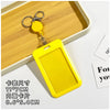 Yellow plastic ID badge holder with a keychain attached, shown resting on a wooden tray.