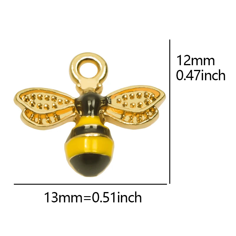 A gold-colored bee enamel charm with a yellow and black body and wings, shown next to a dimension scale.