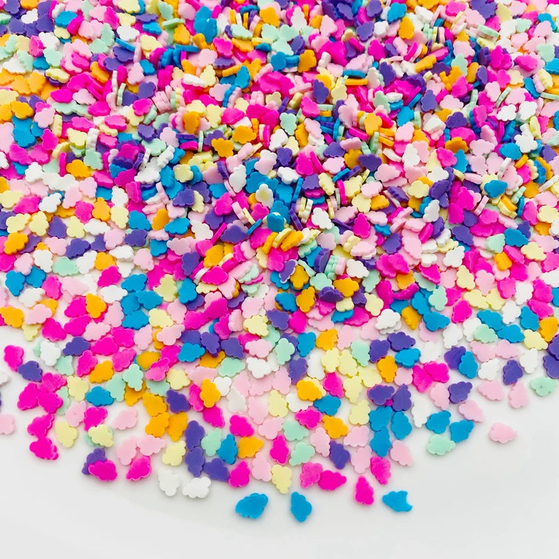 A pile of colorful polymer clay star and heart sprinkles in various shades of pink, purple, blue, yellow, and white.
