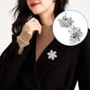 Close-up of a woman wearing a black coat and turtleneck, featuring silver metal locking pin backs for brooches.