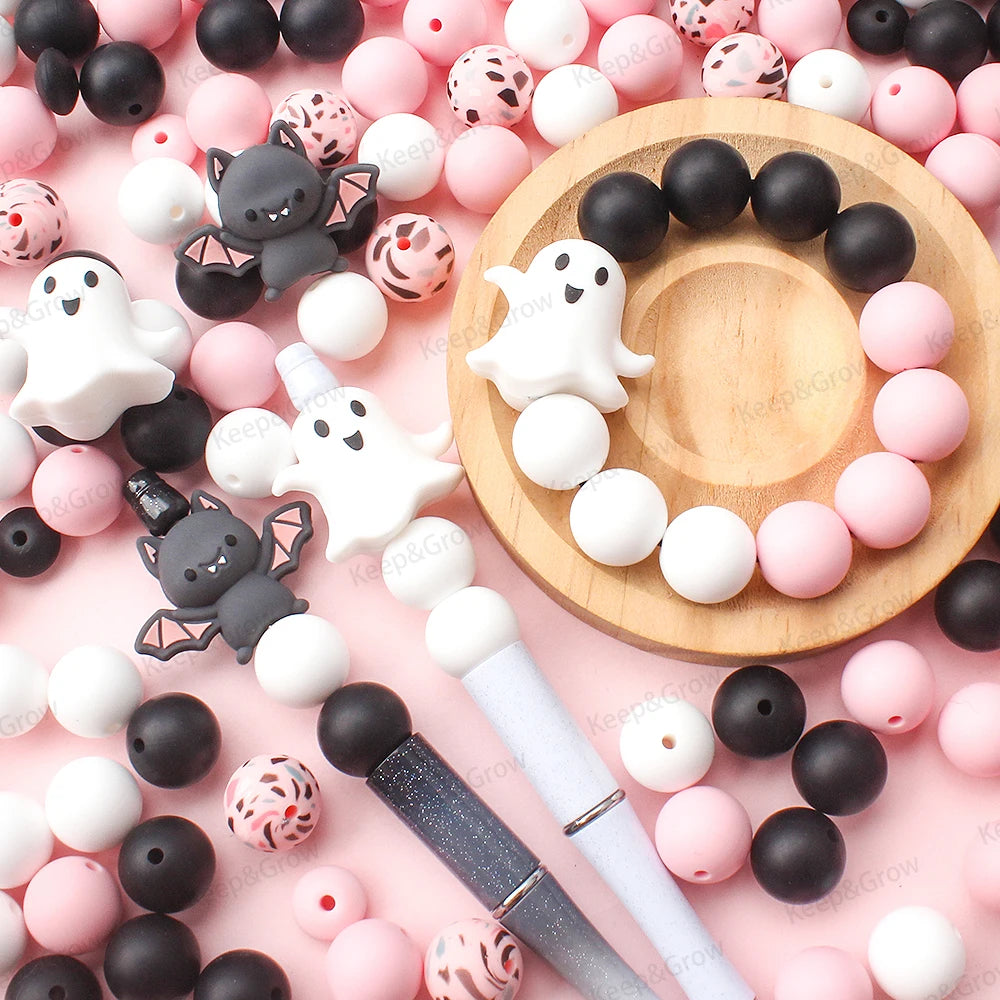 A collection of pink and black silicone crafting beads arranged on a wooden surface.