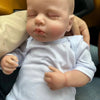 A realistic reborn baby doll with a light blue cloth body is shown in a close-up shot.