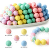 A collection of soft food-grade silicone beads in various pastel colors including pink, yellow, green, and blue.