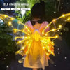 A child wearing a yellow dress with glowing electric wings, illuminated by bright fairy lights.