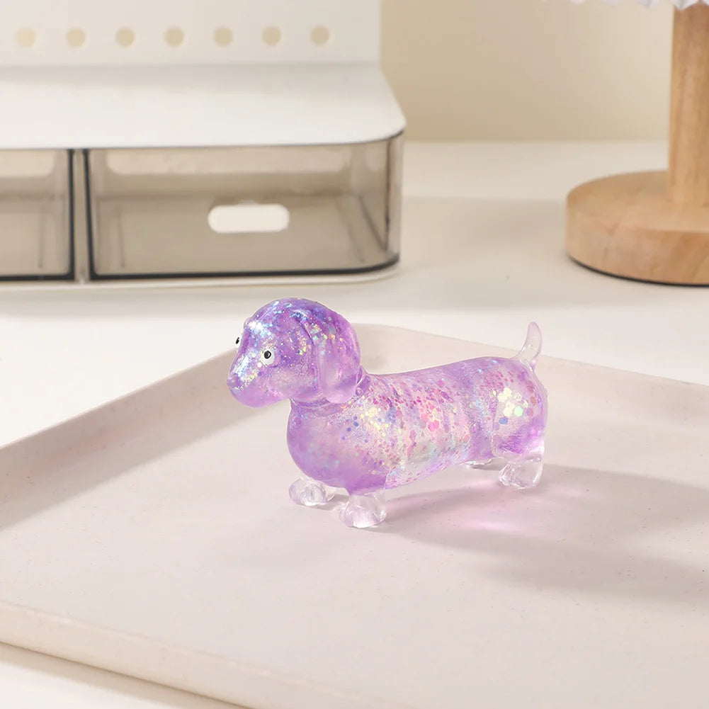 A small, purple, glittery dachshund squishy stress relief toy resting on a white plate.