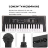A portable electric keyboard piano with a microphone and various accessories shown on a black surface.