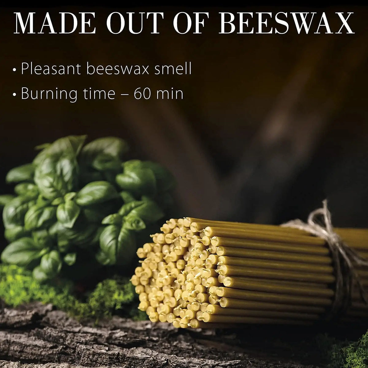 A bundle of natural beeswax taper candles is shown next to green foliage.