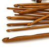 A set of flexible bamboo Tunisian crochet hooks in various sizes arranged diagonally on a white background.